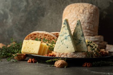 Mutfak masasında peynir, ekmek, ceviz ve kekik. Boşluğu kopyala.