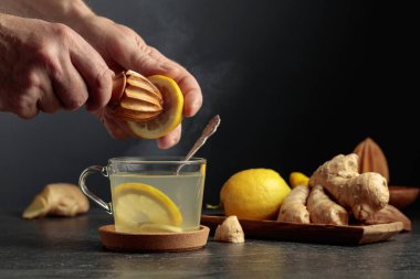 Limonlu ve ballı zencefil çayı. Meyve suyu eski bir tahta sıkacağıyla limondan sıkılır. Boşluğu kopyala.