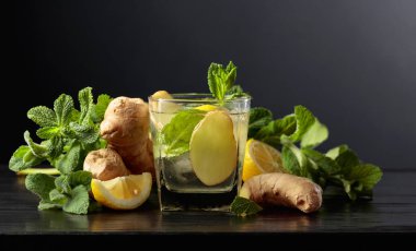 Buzlu, zencefilli, limonlu ve siyah arkaplanda naneli içecek..