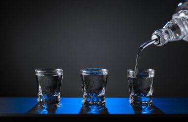 Alkolik votka kadehleri ya da küçük bardaklarda sert içkiler. Barmen sert ruhu bardaklara doldurur, servis ve içecekler hakkında konsept yapar. Boşluğu kopyala.