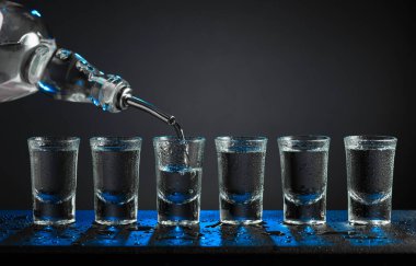 Alkolik votka kadehleri ya da küçük bardaklarda sert içkiler. Barmen sert ruhu bardaklara doldurur, servis ve içecekler hakkında konsept yapar. Boşluğu kopyala.