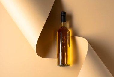 Bej arka planda bir şişe beyaz şarap. Üst Manzara. Boşluğu kopyala.