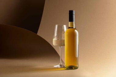 Bej arka planda bir şişe beyaz şarap..