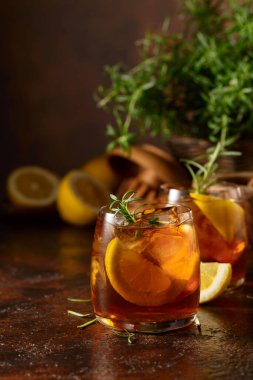 Buzlu çay veya eski kahverengi masada buzlu, biberiyeli ve limonlu alkollü kokteyl. Taze, sağlıklı, soğuk limon suyu. Buzlu ve limonlu çay..