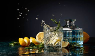 Limon ve biberiyeli cin tonik kokteyli. Limon dilimi bardağa dökülür Kokteylle.