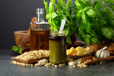 Pesto sosu ve malzemeler siyah taş bir masada. Geleneksel İtalyan pesto tarifi.