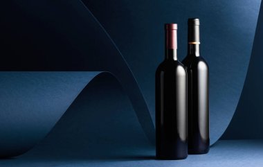 Kırmızı arka planda kırmızı şarap şişeleri. Boşluğu kopyala.