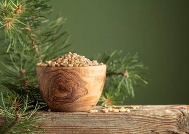 Soyulmuş çam fıstığı ve sedir dalı eski bir ahşap masada. Boşluğu kopyala.