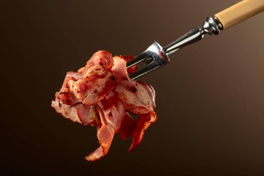 Kahverengi arka planda kızarmış pastırma dilimleri. Kızarmış domuz pastırması..