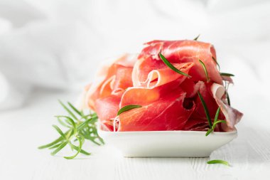 Beyaz ahşap bir masada biberiyeli jambon. Geleneksel İtalyan atıştırması.