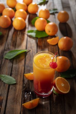 Klasik tekila gündoğumu kokteyli, portakal suyu ve nar şurubunun katmanlı renkleri, bir şişe maraska şişi ile süslenmiş..