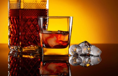 Siyah yansıtıcı arka planda buzlu viski. Boşluğu kopyala.