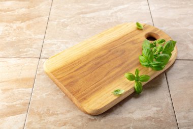 Mutfak masasında tahta ve fesleğen kesiyorum. Mutfak geçmişi. Boş tahta kesme tahtası, ürün görüntüleme alanı.