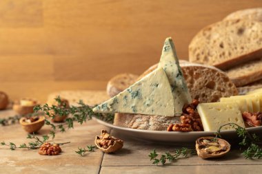 Mutfak masasında peynir, ekmek, ceviz ve kekik. Boşluğu kopyala.