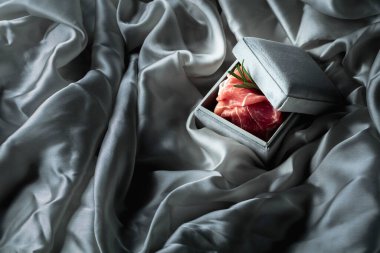 Gri bir hediye kutusunda biberiyeli jambon. Pahalı yemek teması. Boşluğu kopyala.