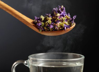 Bitki çayı ve sıcak suyla yapılmış kupa için kurutulmuş mallow çiçeği..