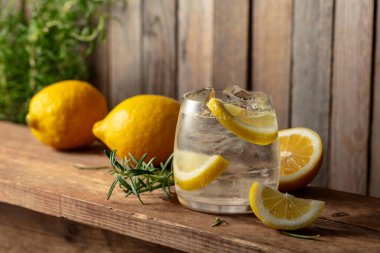 Eski ahşap bir masada buzlu, biberiyeli ve limonlu yaz ferahlatıcı bir içecek. Taze, sağlıklı, soğuk limon suyu. Buzlu ve limonlu su.