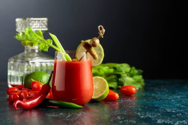 Salatalık, zeytin, limon ve kereviz ile süslenmiş Bloody Mary kokteyli. Siyah arkaplanda kırmızı biber, turşu, zeytin, limon ve kereviz ile domates suyu..