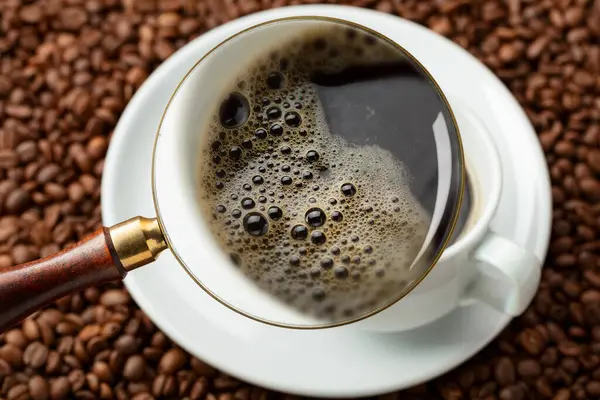 stock image Espresso under a magnifying glass. Focus on a foam. Conceptual image on the theme of coffee.