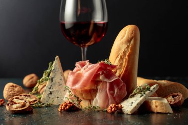 Mavi peynirli jambon, kırmızı şarap, baget, ceviz ve kekik. Geleneksel Akdeniz atıştırmalıkları ile kırmızı şarap.
