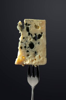 Blue cheese slice on a black background.