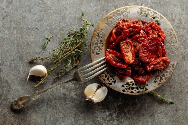 Zeytin yağında kurutulmuş domates kekik ve sarımsak eski bir taş masanın üzerinde. Üst görünüm.
