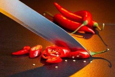 Bıçak ve kırmızı biber siyah masada..