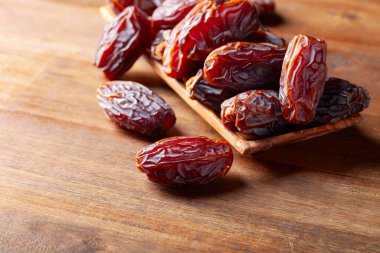 Eski ahşap bir masada sulu olgun tarihler.