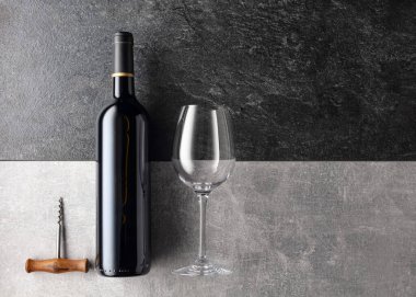 Taş zeminde bir şişe kırmızı şarap. Üst görünüm.