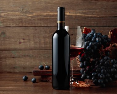 Red wine and blue grapes. Wine and grapes in a vintage setting on an old wooden table.