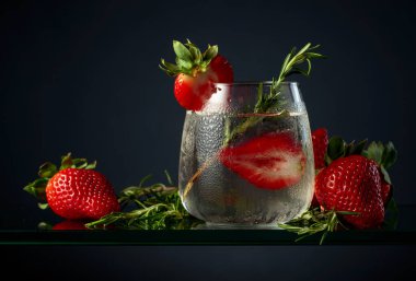 Buzlu, çilekli ve biberiyeli kokteyl cin toniği..