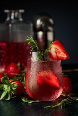 Buzlu, çilekli ve biberiyeli cin tonik. Donmuş bardaktaki doğal buzla ferahlatıcı içecek..