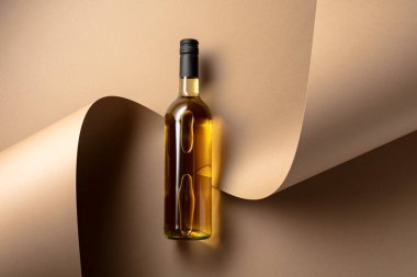 Bej arka planda bir şişe beyaz şarap. Üst Manzara. Boşluğu kopyala.