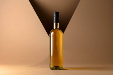 Bottle of white wine on a beige background. Copy space.