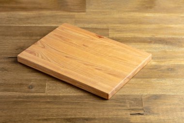 Ahşap bir masanın tahta kesme tahtası. Mutfak geçmişi. Boş tahta kesme tahtası, ürün görüntüleme alanı.