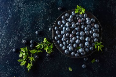 Siyah bir arka planda siyah tabakta yaban mersini. Üst görünüm.