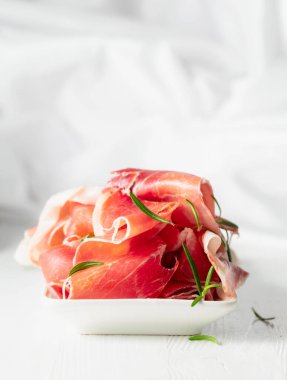 Beyaz ahşap bir masada biberiyeli jambon. Geleneksel İtalyan atıştırması.