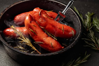 Kızarmış Bavyera sosisi ve biberiye eski siyah bir tavada.