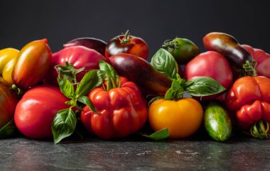 Siyah arka planda farklı türde domates ve fesleğen yaprakları..