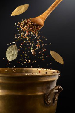Kurutulmuş organik baharat karışımı eski bir pirinç tavaya dökülür. Salamura yapmak için baharatlar.