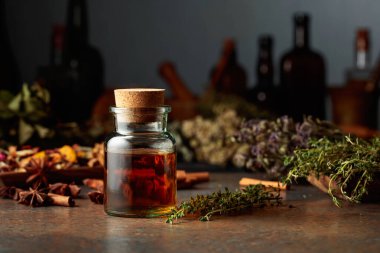 Küçük bir cam şişede gerekli bitkisel tentür. Kurutulmuş otlar, çiçekler, baharatlar ve eski mutfak aletleri. Alternatif ya da tamamlayıcı ilaç tedavisi.