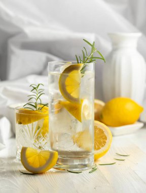 Beyaz masada buzlu, biberiyeli ve limonlu yaz ferahlatıcı kokteyl.. 