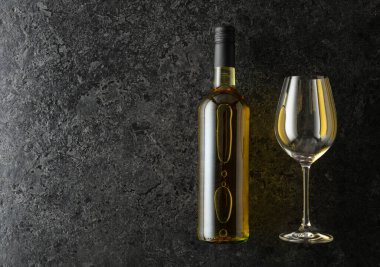 Siyah taşlı arka planda bir şişe beyaz şarap. Boşluğu kopyala.