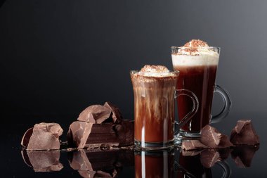 Krem şanti ve koyu bir arka plan üzerinde koyu çikolata parçaları ile sıcak çikolata. Kopyalama alanı.