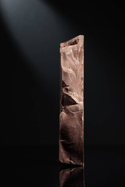 Siyah arka planda büyük bir parça siyah çikolata..