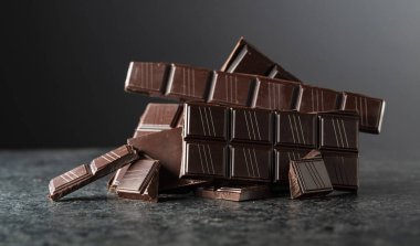 Siyah arka planda kırılmış acı çikolata. Boşluğu kopyala.