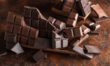 Kahverengi bir arka planda kırık acı ve sütlü çikolatalar..