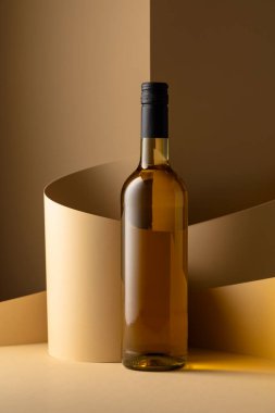 Bottle of white wine on a beige background. Copy space.