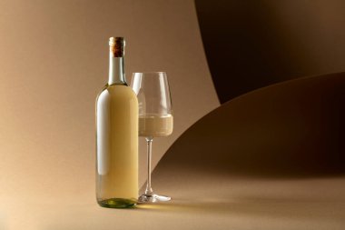 Bej arka planda bir şişe beyaz şarap..