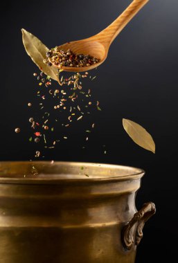 Kurutulmuş organik baharat karışımı eski bir pirinç tavaya dökülür. Salamura yapmak için baharatlar.